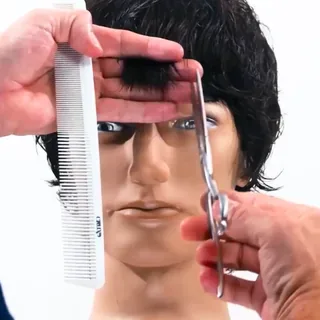 Course still: a dark men's cut, fringe being point cut with shears and comb on a mannequin